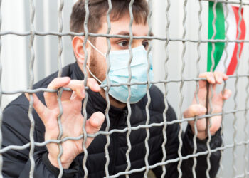 Italy quarantine, stop coronavirus. Italy coronavirus spreading outbreak. Novel coronavirus in Europe EU. Man in medical protective mask with Italian flag in cage. Stop virus epidemic. - Meteo: brutte sorprese ad Halloween, due regioni a rischio pioggia