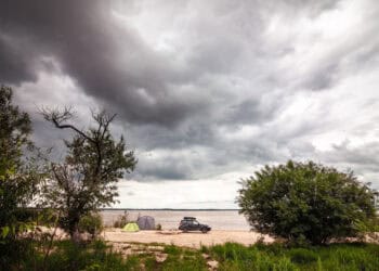 Black SUV with rooftop box near camping at the river. - Incredibile cambiamento meteo: l’anticiclone africano ritarda l’irruzione artica