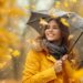 Happy young woman twirling with an umbrella on a rainy autumn day, surrounded by golden foliage - L'Italia e l'impatto devastante delle alluvioni, clima sempre più estremo