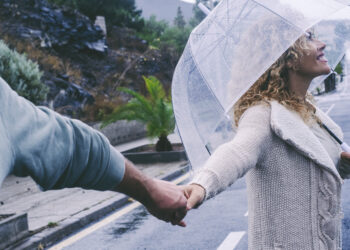 Happy mature couple enjoy life in a rainy day together in romant - Meteo, alluvione devastante in Sicilia a causa del temporale autorigenerante