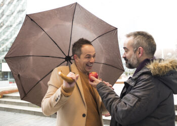 couple of executives offer each other apple on the street in the rain in winter - Possibile ondata di freddo a novembre, ma le conferme ritardano