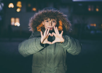 Boy showing love heart with hands outdoors with christmas lights - Tendenza ECMWF: aggiornamenti sulla settimana dell’Immacolata