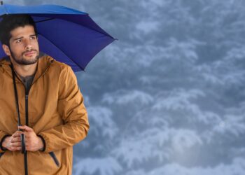 Digital composite of Man with blue umbrella in blue snow forest - Previsioni meteo: la prossima settimana tra caldo e freddo