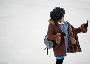 Curly hair african american woman wear on sheepskin coat and glo - Meteo: Dicembre prepara il terreno per la prima ondata di freddo