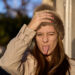 portrait of a woman at sunset looking at the camera with a woolen hat sticking out her tongue with a funny face - Alta pressione e maltempo: non è una contraddizione meteorologica!