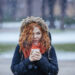 red hair woman holding a cup of hot coffee - Maltempo, tre cicloni consecutivi: shock nel ponte dell’Immacolata