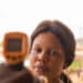 Close-up shot of a young african woman using infrared forehead thermometer (thermometer gun) to check her body temperature for virus symptoms – epidemic virus outbreak concept - Meteo, allarme in Spagna: 'DANA' di nuovo protagonista?