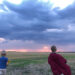 Two children run across a field against the background of clouds at sunset.A boy and a girl in a field against the background of storm clouds - Arriva l’altalena meteo, da clima mite a freddo improvviso