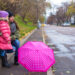 Little girl and her ​​mother walking  with umbrella on a rainy day - Meteo prossima settimana: ancora pioggia e neve, arriva l’inverno