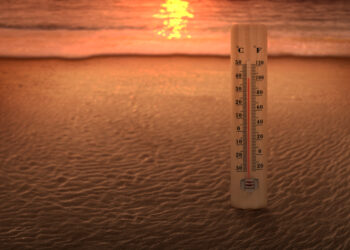 Thermometer measuring the temperature on the beach with a sunset - Meteo: da freddo a caldo, fine novembre senza senso?