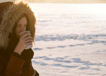 Girl in hood drinks hot coffee on winter day - Meteo: arriva un freddo invernale, possibile rischio di gelate notturne