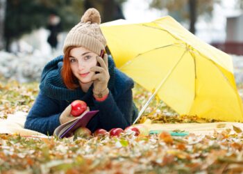 Portrait of beautiful young brunette girl reading a book in the park at fall. - Meteo: con l’anticiclone temperature miti, inversioni e inquinamento