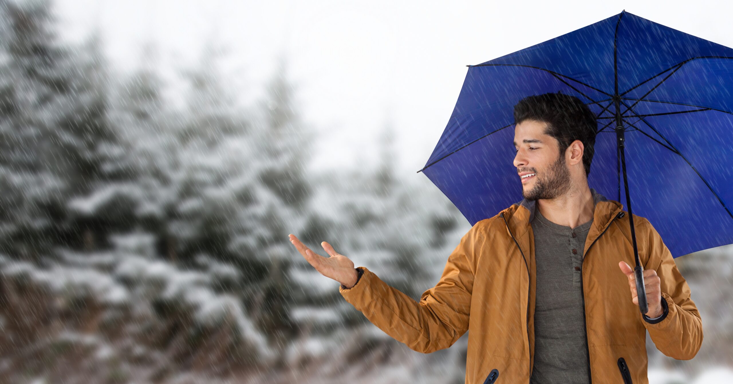 Digital composite of Man with blue umbrella in snow forest - Previsioni meteo settimanali: inizio con piogge e neve, poi variabilità