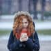 red hair woman holding a cup of hot coffee - Meteo: dal freddo al clima mite, arriva il periodo di svolta