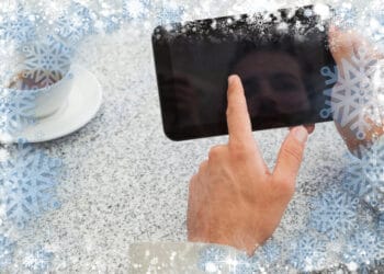 Businessman using small tablet at table against snow - Previsioni meteo Milano: temperature miti, temporale mercoledì sera, poi sole