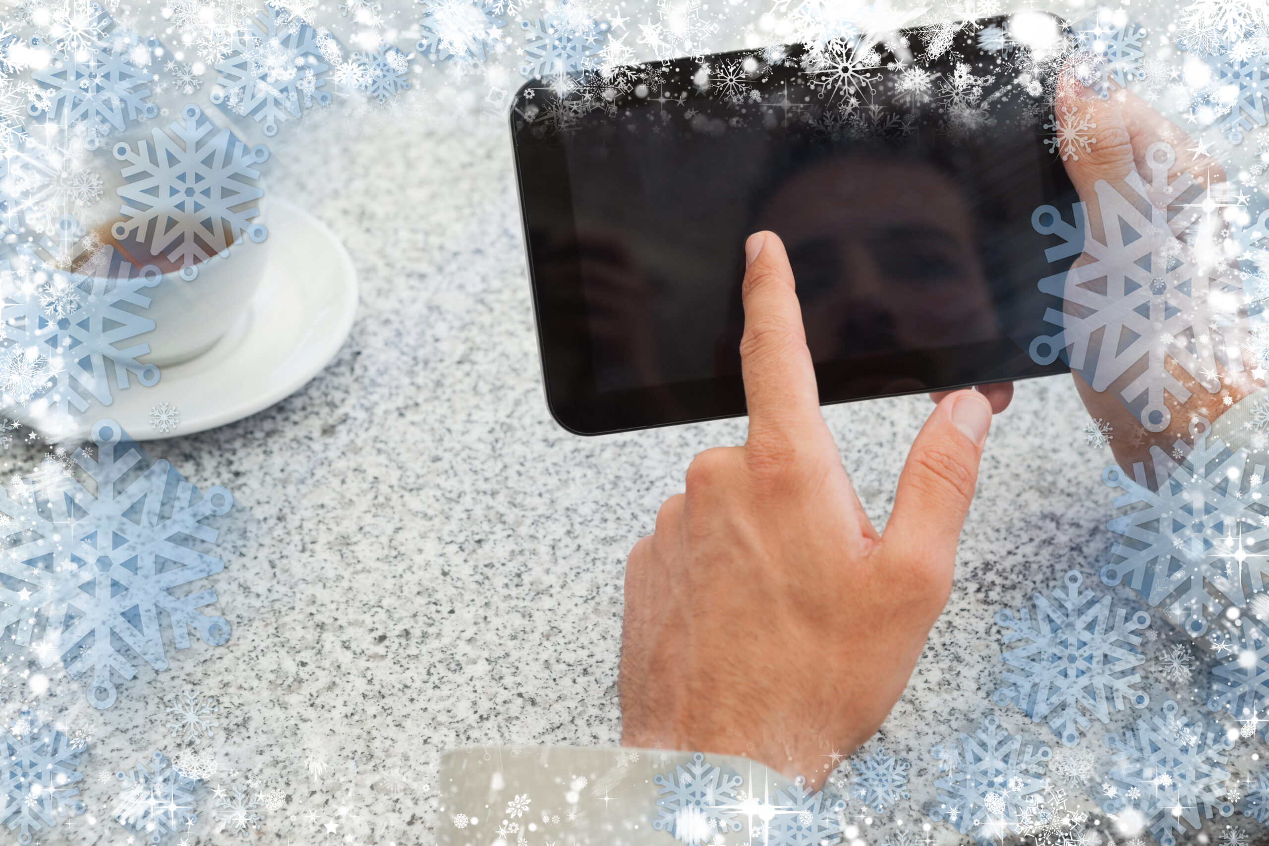 Businessman using small tablet at table against snow - Gelo storico, il meteo di gennaio 2025 farà discutere