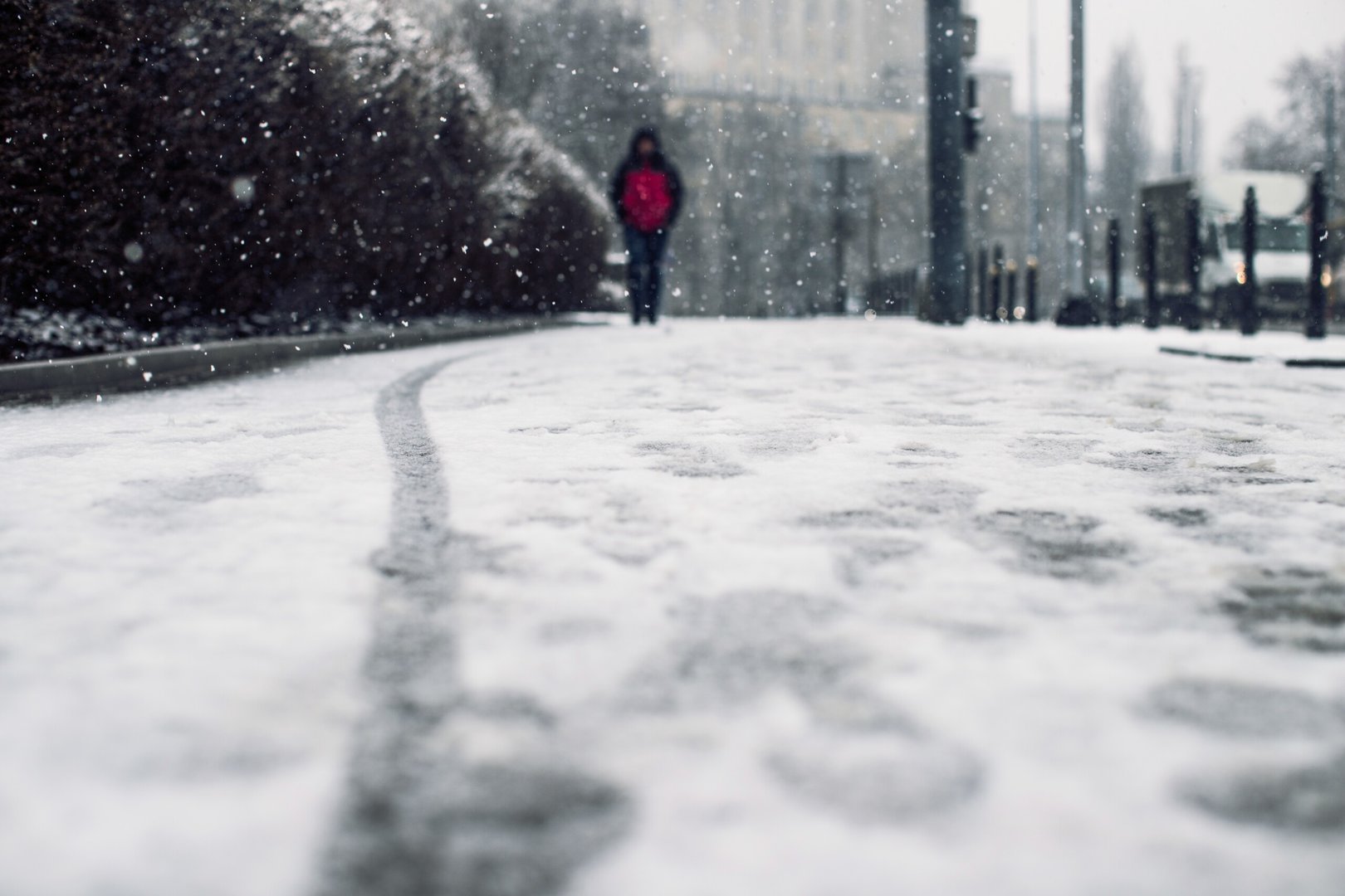 Low angle shot of a person walking on the snow covered sidewalk under the snow - Possibile super nevicata padana tra il 10 e l'11 Gennaio